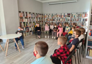 Klasa 1b słucha opowiadania o Basi i bibliotece.